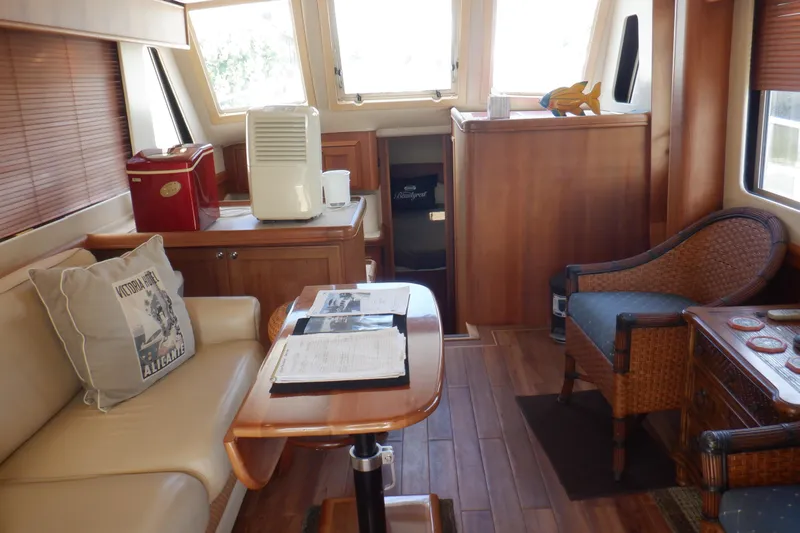 Betty Sue Yacht Photos Pics Interior of 2006 Mainship 34 Trawler with cozy seating and wooden furnishings.