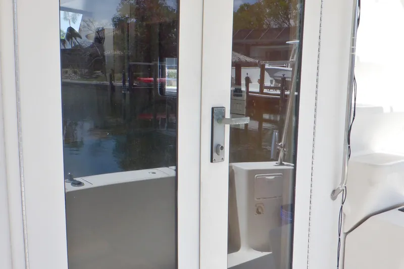 Betty Sue Yacht Photos Pics Glass door on 2006 Mainship 34 Trawler, reflecting marina view.