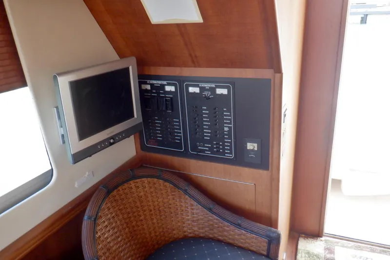 Betty Sue Yacht Photos Pics 2006 Mainship 34 Trawler interior with control panel, TV, and wicker chair.