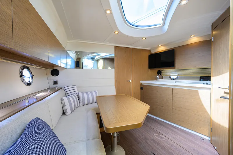  Yacht Photos Pics Interior of 2015 Beneteau 38 GT yacht, featuring modern wood finishes and cozy seating area.