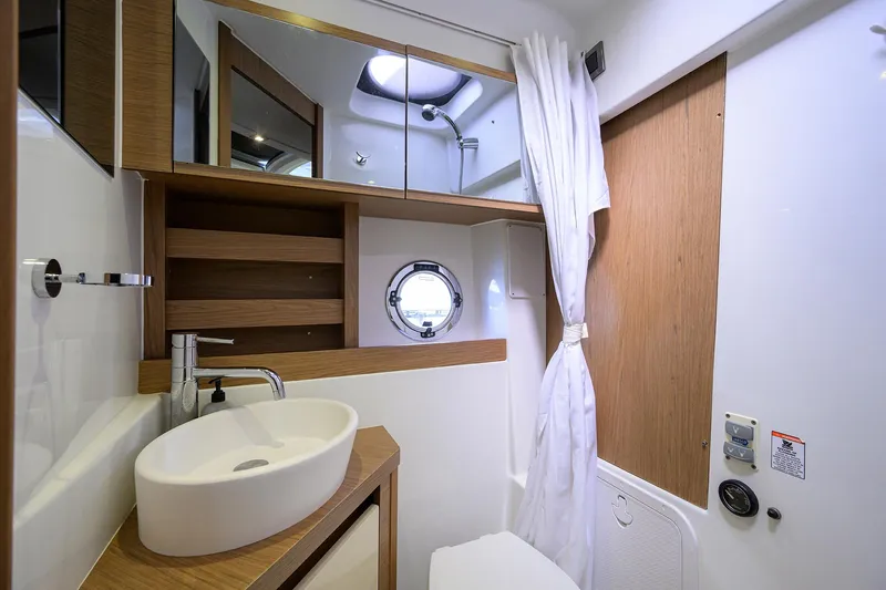  Yacht Photos Pics Modern bathroom in 2015 Beneteau 38 GT yacht with sink, mirror, and porthole.