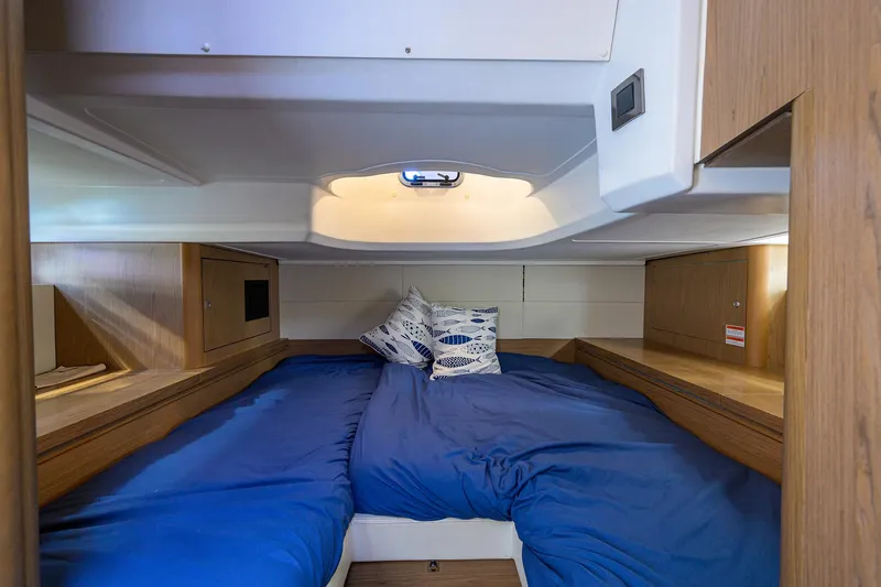  Yacht Photos Pics Cozy cabin interior of 2015 Beneteau 38 GT with blue bedding and wooden accents.
