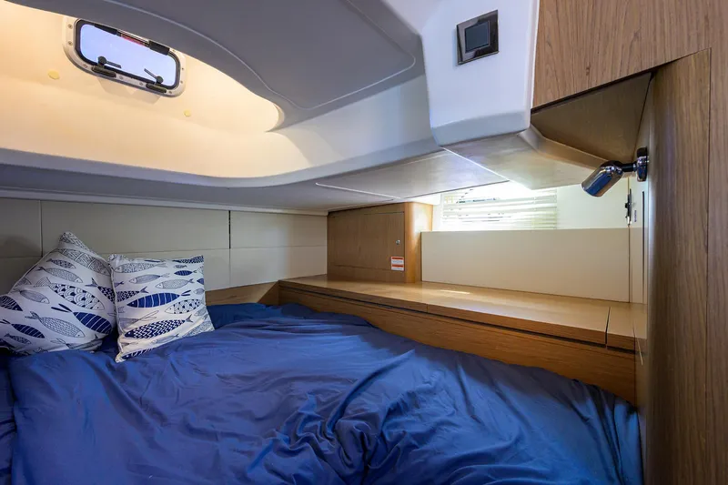  Yacht Photos Pics Cozy cabin interior of 2015 Beneteau 38 GT yacht with blue bedding and pillows.
