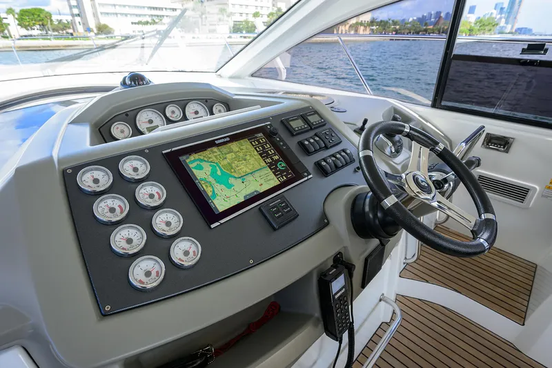  Yacht Photos Pics Beneteau 38 GT 2015 helm with navigation system and gauges, overlooking waterfront.