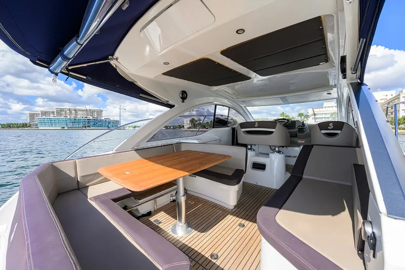  Yacht Photos Pics Luxurious 2015 Beneteau 38 GT yacht interior with seating and table, docked by waterfront.