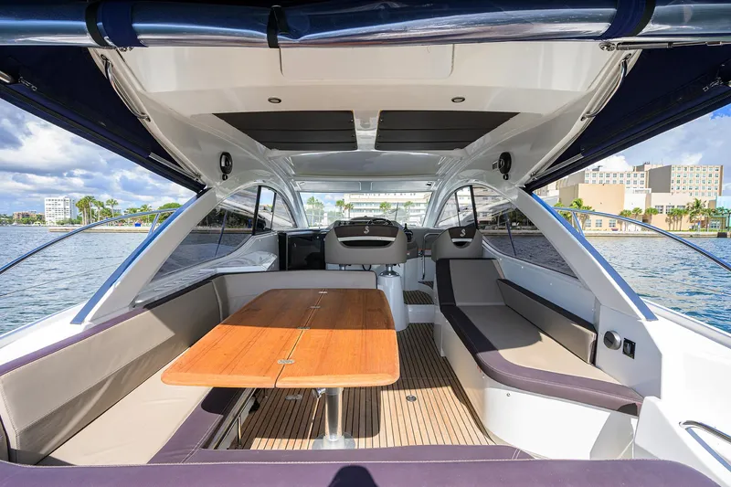  Yacht Photos Pics Interior view of 2015 Beneteau 38 GT yacht with spacious seating and wooden table.