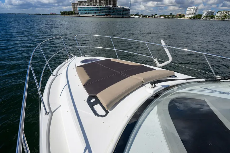  Yacht Photos Pics Beneteau 38 GT 2015 yacht with sunbathing area on deck, cruising near city skyline.
