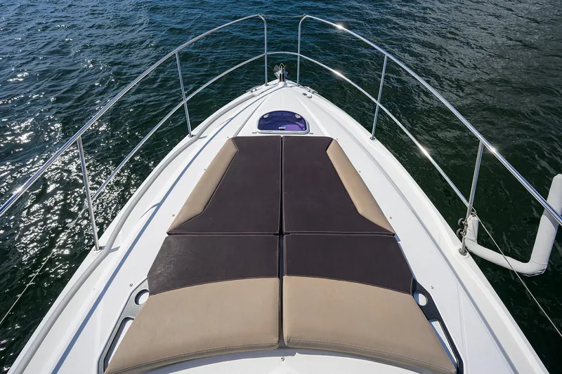  Yacht Photos Pics 2015 Beneteau 38 GT yacht bow with sunpad, surrounded by water.