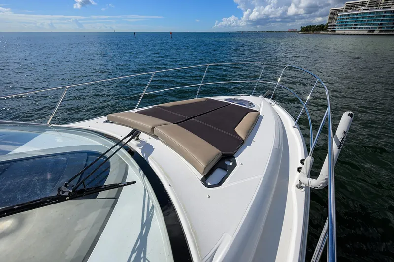  Yacht Photos Pics Beneteau 38 GT 2015 yacht on calm sea with sunpad, clear sky, and distant shoreline.