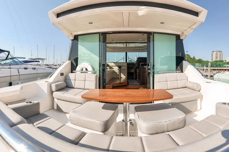 Escapade Yacht Photos Pics 2017 Tiara Yachts C44 Coupe with spacious outdoor seating and elegant wooden table.