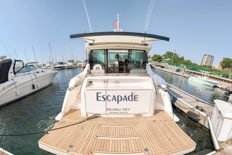 Escapade Yacht Photos Pics 2017 Tiara Yachts C44 Coupe docked at marina, rear view with "Escapade" name.