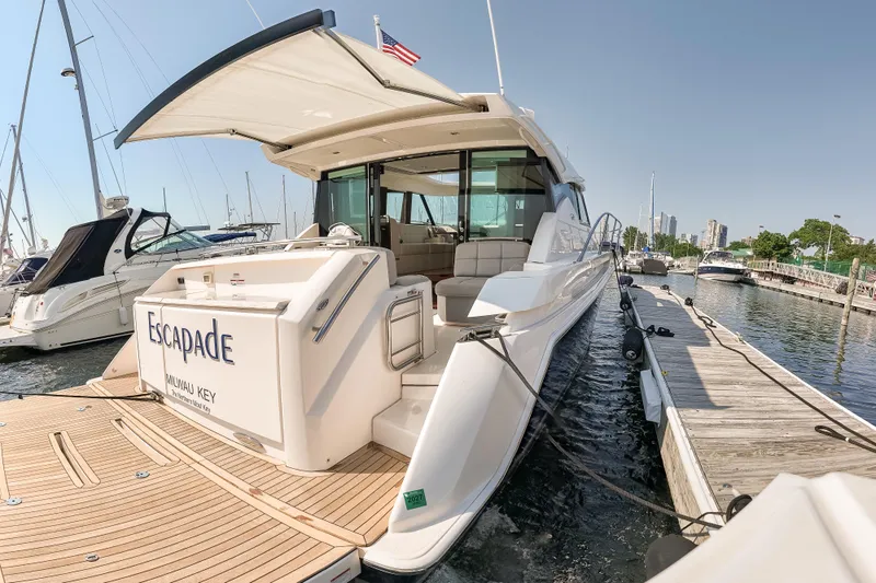 Escapade Yacht Photos Pics 2017 Tiara Yachts C44 Coupe docked at marina, rear view with open deck.