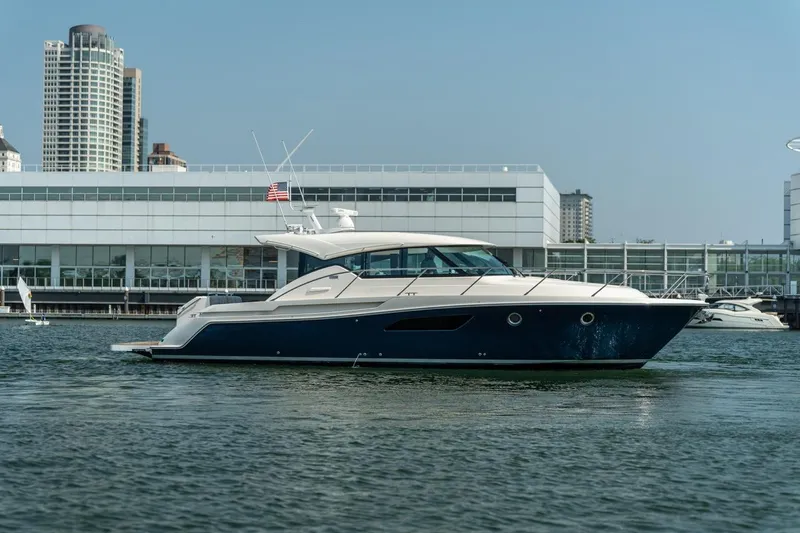 Escapade Yacht Photos Pics 2017 Tiara Yachts C44 Coupe in marina, cityscape background.