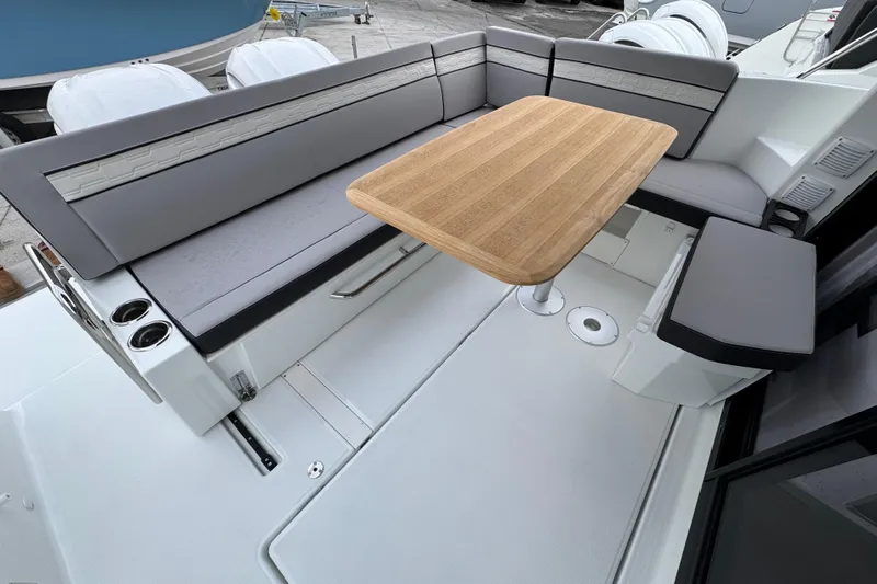  Yacht Photos Pics 2026 Jeanneau NC 1095 boat interior with sleek seating and wooden table.