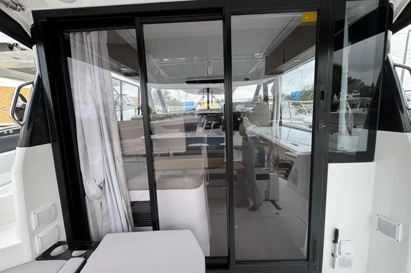  Yacht Photos Pics 2026 Jeanneau NC 1095 boat interior with sliding glass doors and modern design.