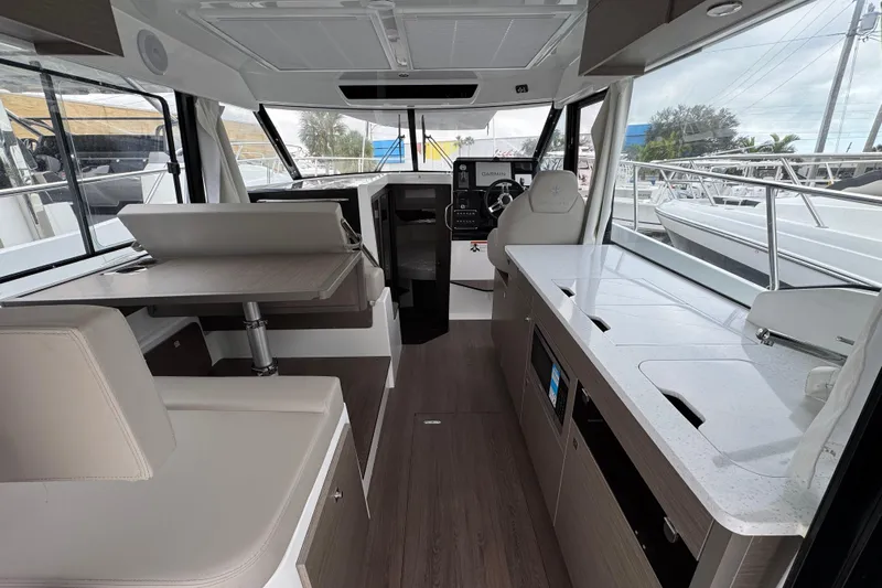  Yacht Photos Pics Interior of 2026 Jeanneau NC 1095 boat with modern seating and navigation area.