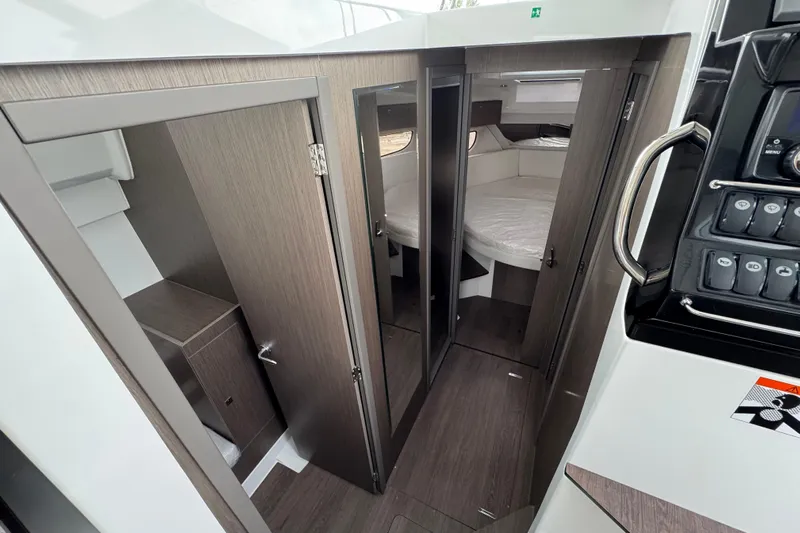  Yacht Photos Pics 2026 Jeanneau NC 1095 interior cabin with modern wood finish and cozy sleeping area.