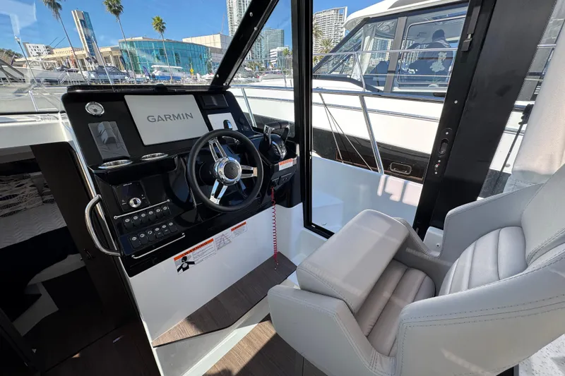  Yacht Photos Pics 2026 Jeanneau NC 1095 helm with Garmin navigation, modern controls, and comfortable seating.