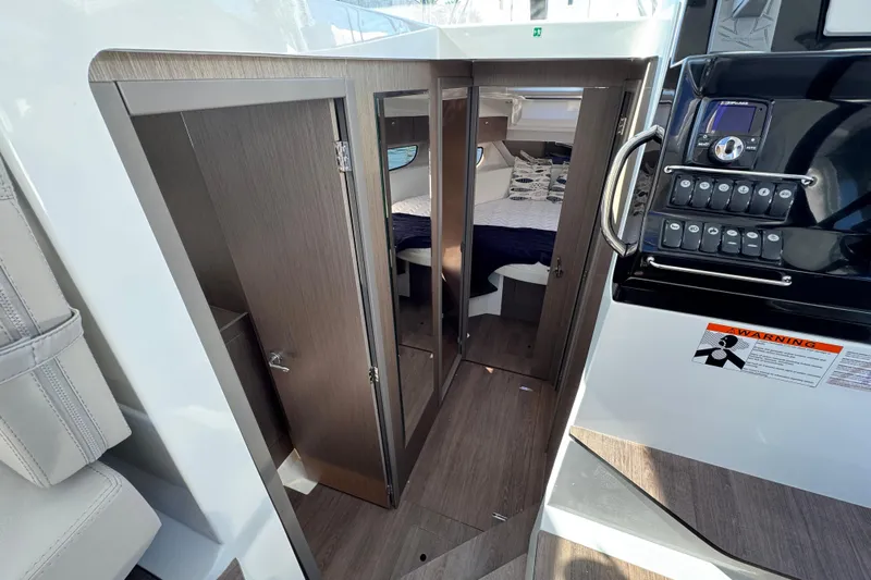  Yacht Photos Pics 2026 Jeanneau NC 1095 interior cabin with modern wood finish and control panel.