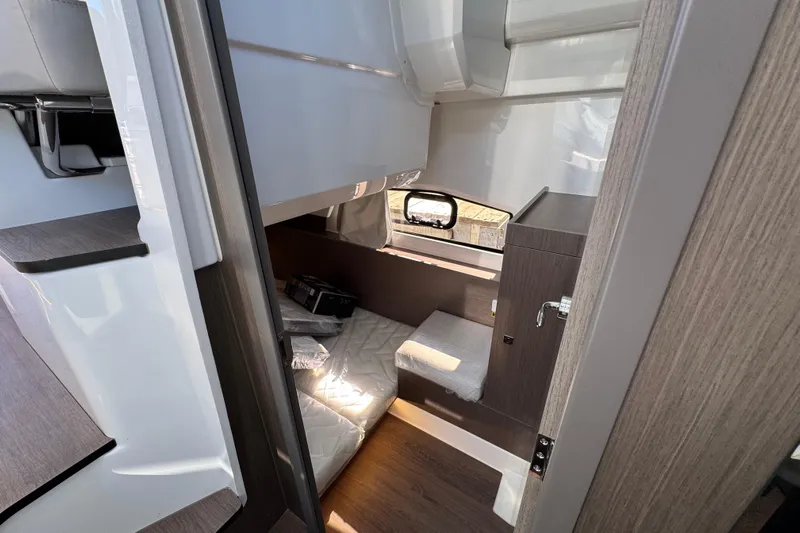  Yacht Photos Pics Interior cabin of 2026 Jeanneau NC 1095 boat, featuring modern design and cozy sleeping area.