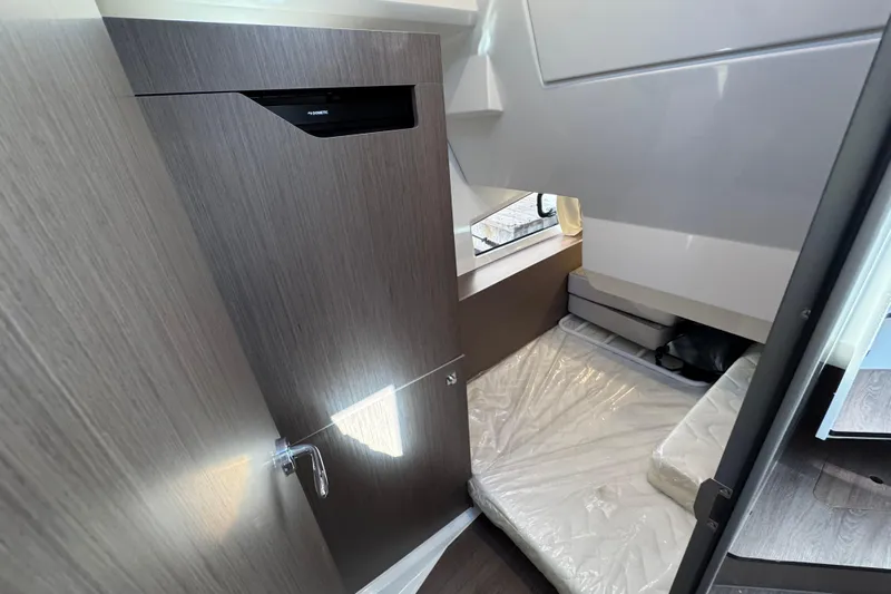  Yacht Photos Pics 2026 Jeanneau NC 1095 cabin interior with bed and wooden cabinetry.