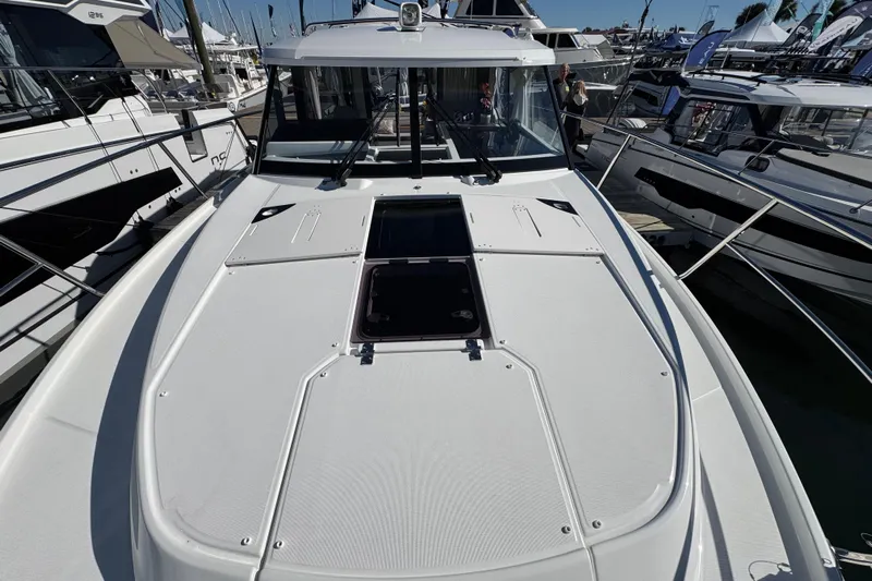  Yacht Photos Pics 2026 Jeanneau NC 1095 boat deck at marina, showcasing sleek design and spacious layout.