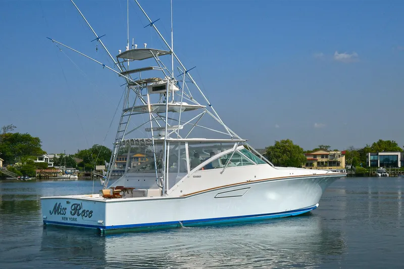 Yacht Photos Pics 1999 Cabo 45 Express boat on calm water, clear sky background.