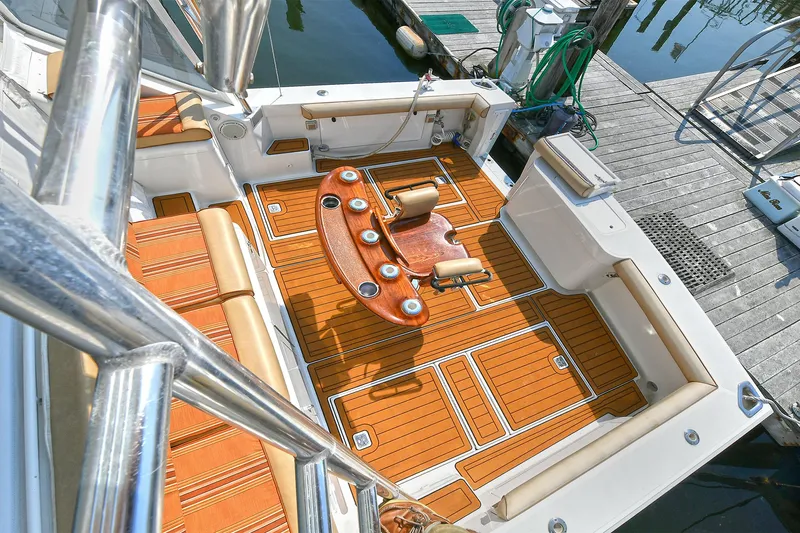  Yacht Photos Pics 1999 Cabo 45 Express boat deck with wooden flooring and fishing chair.