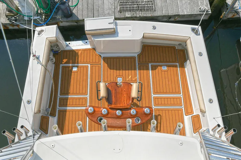  Yacht Photos Pics 1999 Cabo 45 Express boat deck with teak flooring and fishing rod holders.