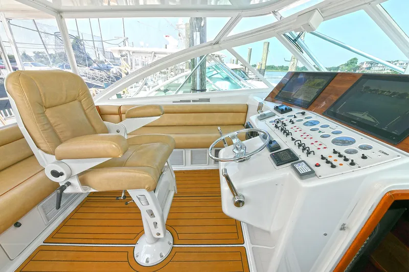  Yacht Photos Pics Helm of 1999 Cabo 45 Express yacht with leather captain's chair and control panel.