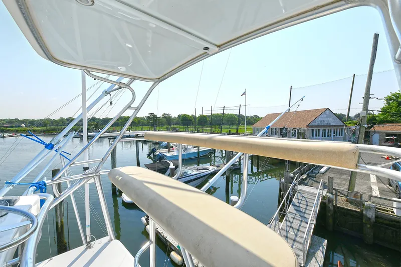  Yacht Photos Pics 1999 Cabo 45 Express yacht docked at a marina with scenic waterfront view.