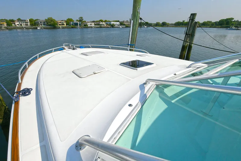  Yacht Photos Pics 1999 Cabo 45 Express yacht docked by a serene waterfront.