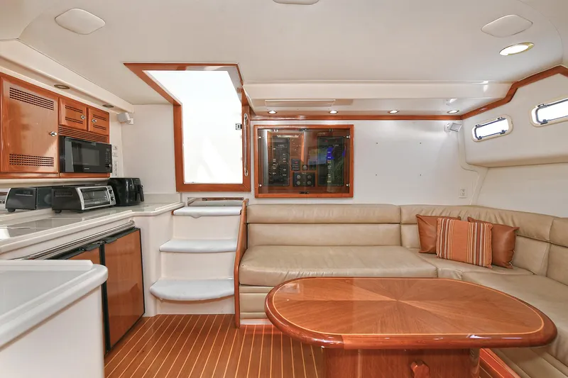  Yacht Photos Pics Luxurious interior of 1999 Cabo 45 Express yacht with elegant wood finishes and cozy seating.