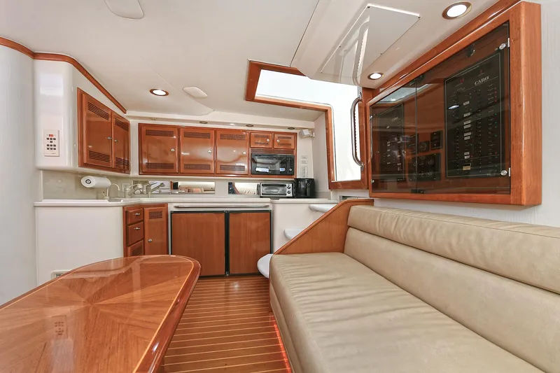  Yacht Photos Pics Interior of 1999 Cabo 45 Express yacht with wooden cabinetry and beige seating.