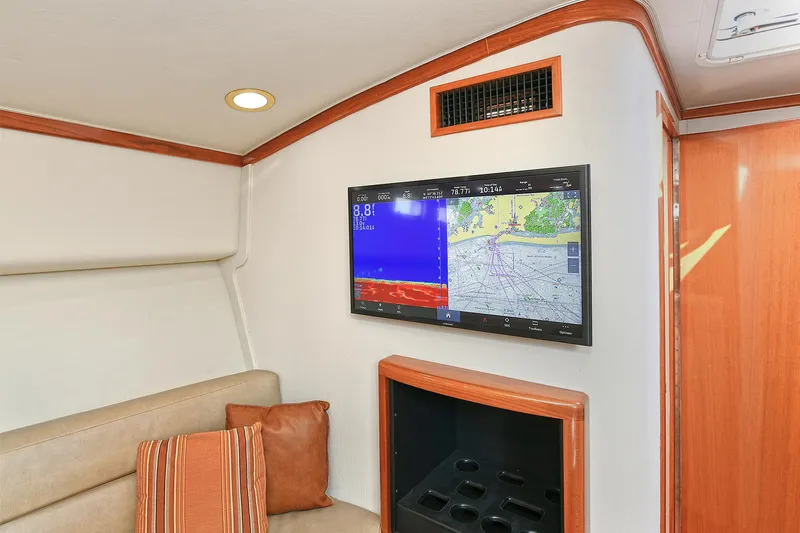  Yacht Photos Pics Interior of 1999 Cabo 45 Express yacht with navigation screen and cozy seating area.