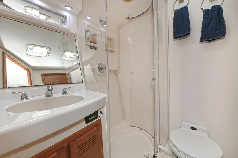  Yacht Photos Pics Luxurious bathroom in 1999 Cabo 45 Express yacht with shower, sink, and toilet.