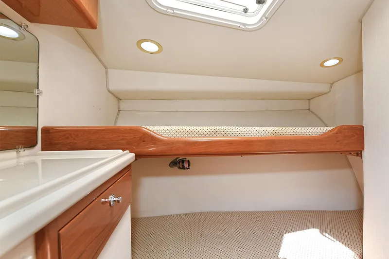  Yacht Photos Pics 1999 Cabo 45 Express cabin interior with bed, wooden accents, and overhead lighting.