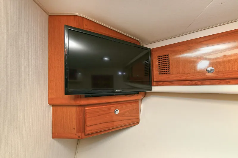  Yacht Photos Pics 1999 Cabo 45 Express interior with mounted TV and wooden cabinetry.