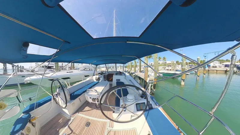 Levity Yacht Photos Pics 2019 Jeanneau Sun Odyssey 479 yacht cockpit with dual steering wheels, docked in a marina.