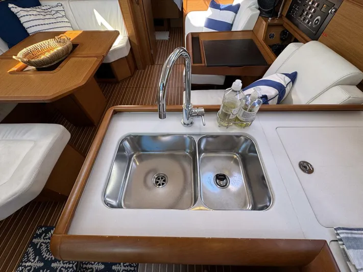 Levity Yacht Photos Pics 2019 Jeanneau Sun Odyssey 479 interior with modern kitchen sink and cozy seating area.