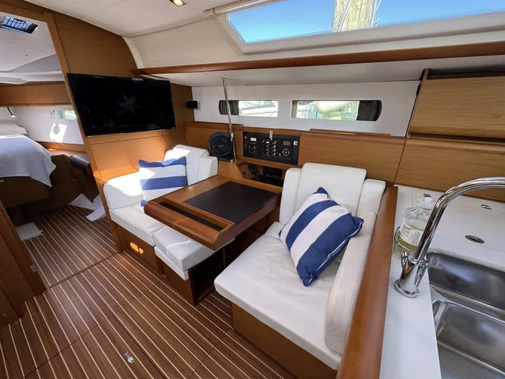 Levity Yacht Photos Pics Interior of 2019 Jeanneau Sun Odyssey 479 yacht with modern seating and striped cushions.