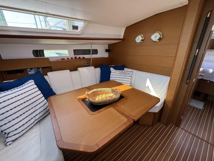 Levity Yacht Photos Pics Interior of 2019 Jeanneau Sun Odyssey 479 yacht with cozy seating and wooden table.