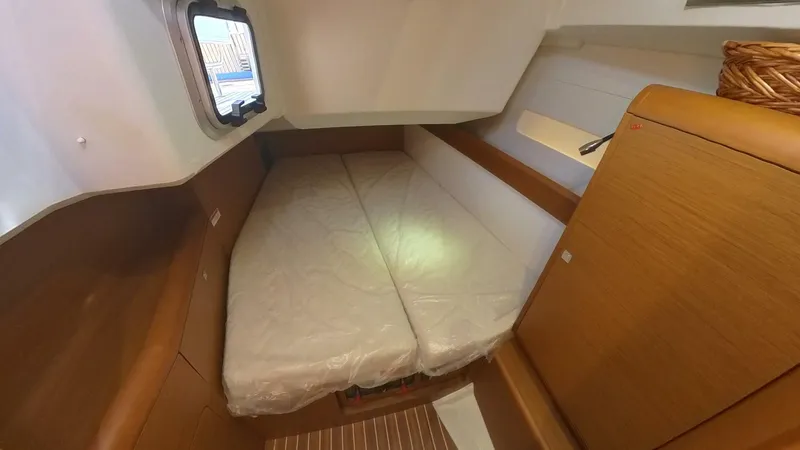 Levity Yacht Photos Pics 2019 Jeanneau Sun Odyssey 479 cabin with bed, wooden interior, and window.