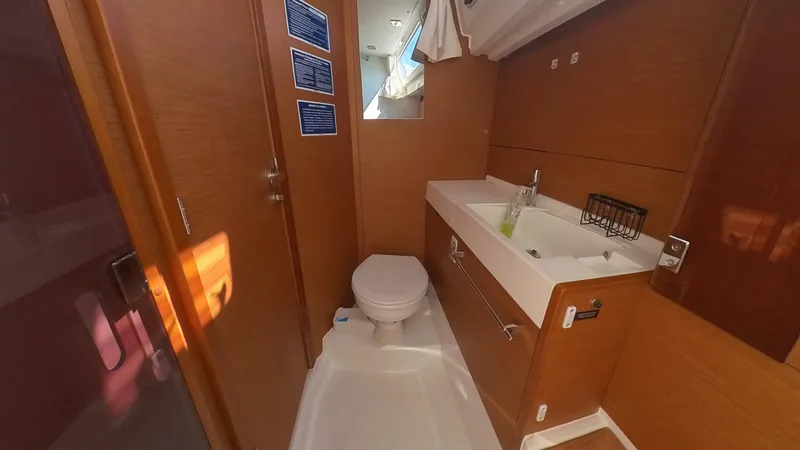 Levity Yacht Photos Pics 2019 Jeanneau Sun Odyssey 479 bathroom with wooden cabinetry, sink, and toilet.