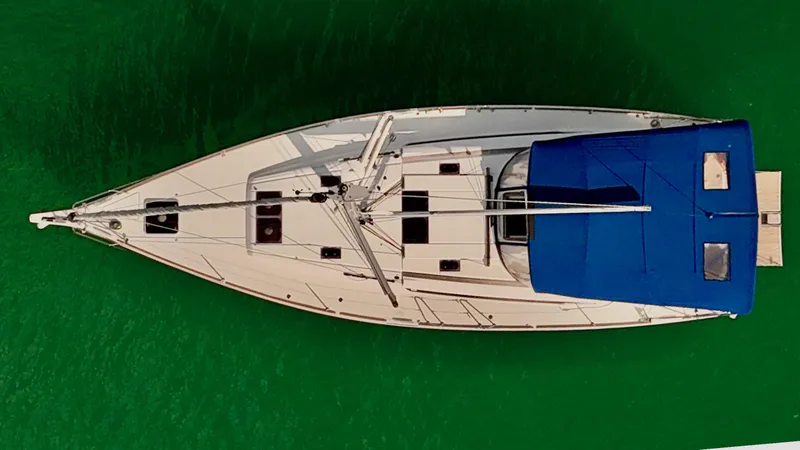 Levity Yacht Photos Pics Aerial view of 2019 Jeanneau Sun Odyssey 479 sailboat on green water.