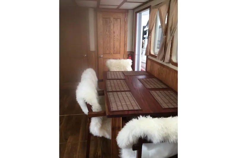Horus Yacht Photos Pics Luxurious dining area on 2013 Custom Trawler 45 with wooden table and plush chairs.