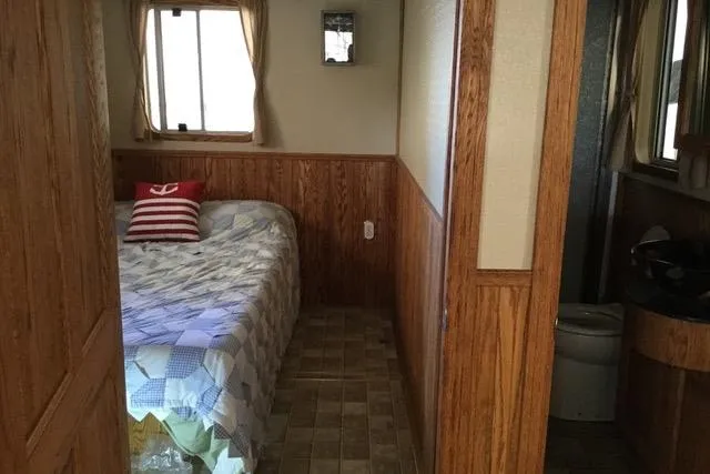 Horus Yacht Photos Pics Cozy bedroom interior of 2013 Custom Trawler 45 with wood paneling and nautical decor.