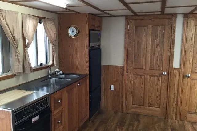 Horus Yacht Photos Pics Kitchen interior of 2013 Custom Trawler 45 with wood cabinetry and modern appliances.