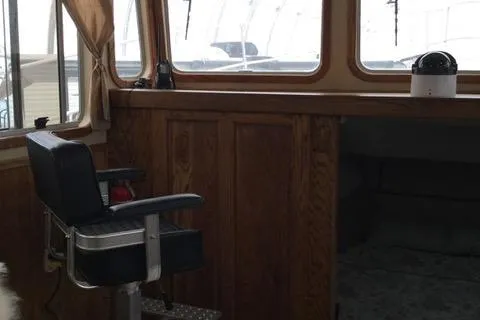 Horus Yacht Photos Pics Interior of 2013 Custom Trawler 45 with wooden paneling and captain's chair.