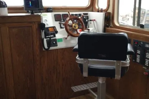 Horus Yacht Photos Pics Pilothouse of 2013 Custom Trawler 45 with wooden wheel and control panel.